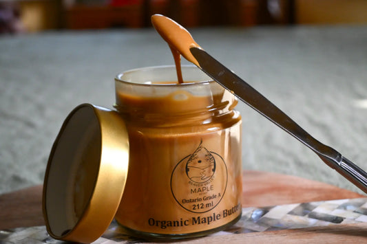 Beaver Valley Organic Maple Butter in an open jar with a knife spreading its creamy texture